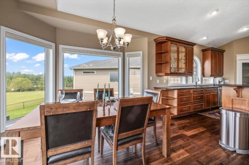 Open-concept dining and kitchen area with dark wood-finish flooring - 215 Westerra Point(E), Stony Plain, AB 