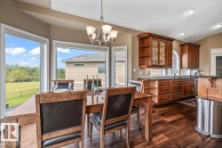 Open-concept dining and kitchen area with dark wood-finish flooring - 