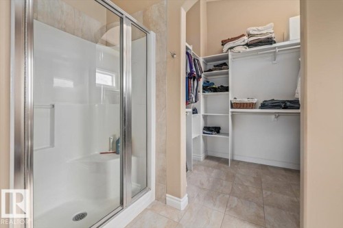 Glass-enclosed shower with integrated seating, a small window, and a built-in towel bar - 215 Westerra Point(E), Stony Plain, AB 