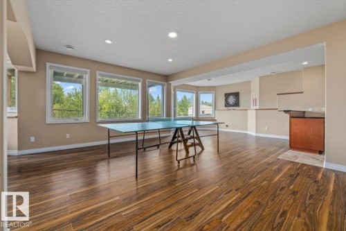 Spacious room featuring wood-finish flooring, recessed lighting, and multiple windows - 215 Westerra Point(E), Stony Plain, AB 