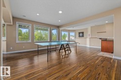 Spacious room featuring wood-finish flooring, recessed lighting, and multiple windows - 