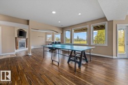 Spacious lower-level area featuring wood-finish flooring, recessed lighting, and large windows providing ample natural light - 