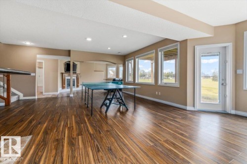 Spacious lower level featuring wood-finish flooring, recessed lighting, and a fireplace with a wood mantle - 215 Westerra Point(E), Stony Plain, AB 