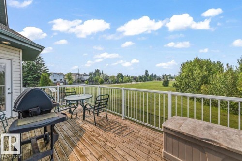 Expansive wood-finish deck with white railing, offering abundant outdoor space - 215 Westerra Point(E), Stony Plain, AB 