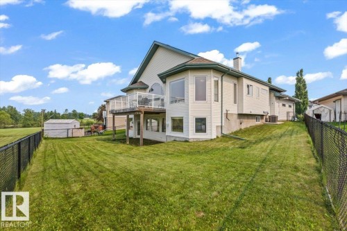 Rear exterior with light-toned siding and a multi-level structure - 215 Westerra Point(E), Stony Plain, AB 