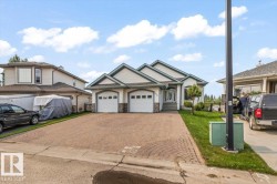 Two-car garage with white paneled doors and decorative windows - 
