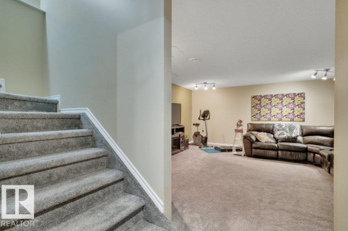 Carpeted stairs with white trim leading to a spacious lower-level area - 6042 214 Street, Edmonton, AB - Indoor Photo Showing Other Room