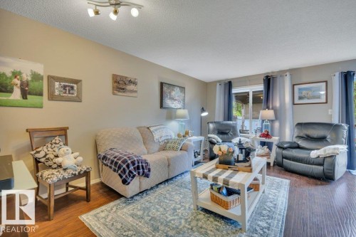 Living area featuring hardwood, light-colored walls, and a sliding glass door - 6042 214 Street, Edmonton, AB - Indoor Photo Showing Living Room
