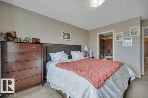 Carpeted bedroom featuring neutral wall tones and a textured headboard - 6042 214 Street, Edmonton, AB - Indoor Photo Showing Bedroom