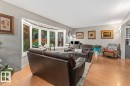 Living area featuring wood-finish flooring and a prominent bay window - 6720 29 Avenue, Edmonton, AB 