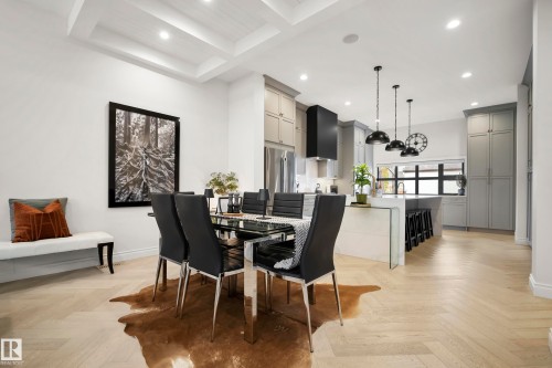 Open-concept dining area featuring a coffered ceiling, recessed lighting, and light wood-finish flooring in a herringbone pattern - 6115 111 Avenue, Edmonton, AB - Indoor Photo Showing Dining Room