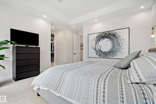 Recessed lighting illuminating a spacious room with light-toned carpeting and a wide doorway revealing a built-in closet system - 6115 111 Avenue, Edmonton, AB - Indoor Photo Showing Bedroom