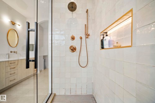 Walk-in shower featuring a glass enclosure with matte black hardware, white square tile, and brushed bronze fixtures - 6115 111 Avenue, Edmonton, AB - Indoor Photo Showing Bathroom