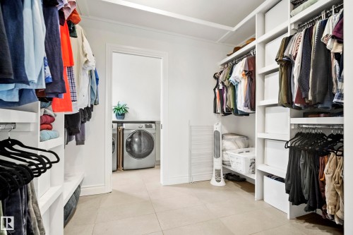 Walk-in closet featuring white built-in shelving, multiple hanging rods, and light-colored tile flooring - 6115 111 Avenue, Edmonton, AB - Indoor With Storage