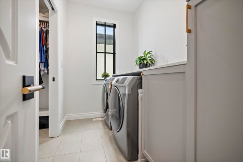 Laundry area featuring built-in cabinetry, an integrated countertop, and a window with black trim - 6115 111 Avenue, Edmonton, AB - Indoor Photo Showing Laundry Room