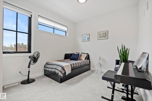 Light-filled room featuring two windows with black frames, white walls, and light-toned carpeting - 6115 111 Avenue, Edmonton, AB - Indoor Photo Showing Other Room