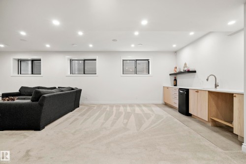 Spacious recreation room featuring recessed lighting, light-toned carpeting, and multiple windows - 6115 111 Avenue, Edmonton, AB - Indoor