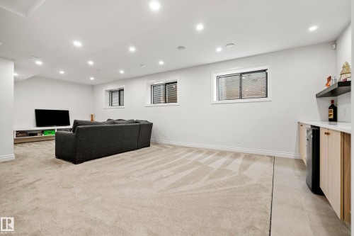 Spacious lower-level entertainment area featuring recessed lighting, light-toned carpeting, and multiple windows - 6115 111 Avenue, Edmonton, AB - Indoor