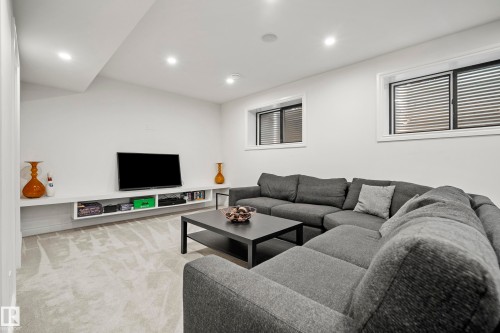 Entertainment space featuring light-colored carpeting, recessed lighting, and a built-in floating media console - 6115 111 Avenue, Edmonton, AB - Indoor Photo Showing Living Room