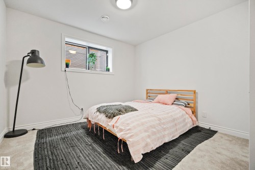 Carpeted room with a single window featuring horizontal blinds and a window well - 6115 111 Avenue, Edmonton, AB - Indoor Photo Showing Bedroom