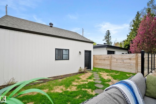 Exterior featuring vertical panel siding and a dark roofline - 6115 111 Avenue, Edmonton, AB - Outdoor