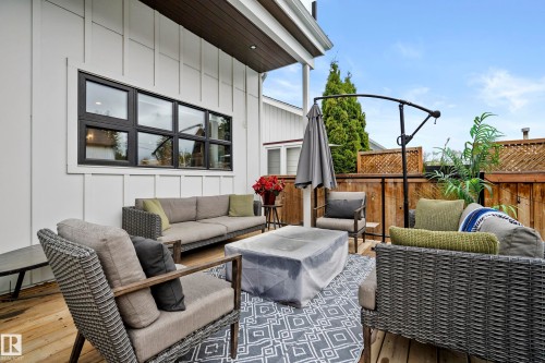 Outdoor deck featuring wood-finish flooring, white board and batten siding, and a privacy fence - 6115 111 Avenue, Edmonton, AB - Outdoor With Deck Patio Veranda With Exterior