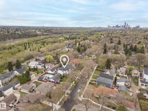 Aerial perspective showcasing a residential neighborhood with mature trees, a river, and a distant city skyline - 6115 111 Avenue, Edmonton, AB - Outdoor With View