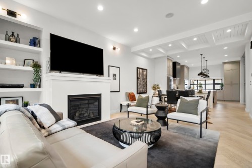 Open-concept living area with a built-in fireplace, recessed lighting, and a coffered ceiling - 6115 111 Avenue, Edmonton, AB - Indoor Photo Showing Living Room With Fireplace