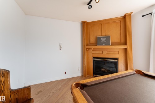 Recessed fireplace with an ornate wooden mantel and surround - 183 Dechene Road, Edmonton, AB 
