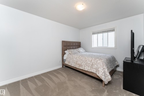 Carpeted room featuring a white ceiling and walls, white baseboards, and a window with white blinds - 183 Dechene Road, Edmonton, AB 