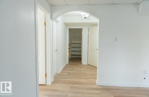Interior hallway featuring wood-finish flooring and white walls - 183 Dechene Road, Edmonton, AB 