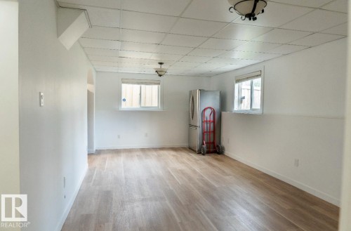 Open-concept space featuring wood-finish flooring, white painted walls, and ceiling-mounted light fixtures - 183 Dechene Road, Edmonton, AB 