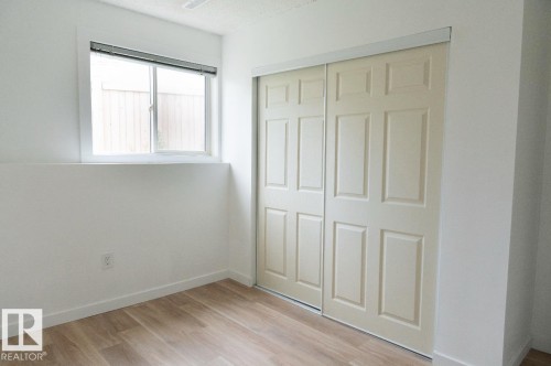 Room featuring wood-finish flooring and a white baseboard trim - 183 Dechene Road, Edmonton, AB 