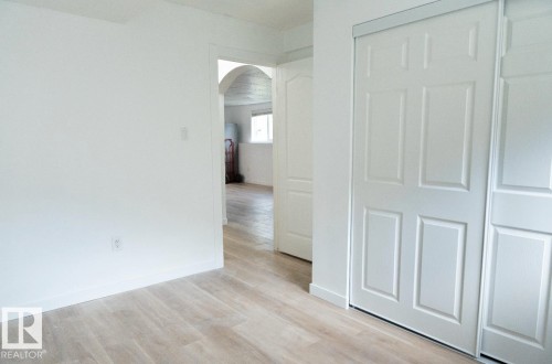 Light wood-finish flooring complements crisp white walls - 183 Dechene Road, Edmonton, AB 