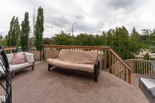 Spacious outdoor deck featuring a composite surface, wooden railings, and a stairway to the yard - 183 Dechene Road, Edmonton, AB 
