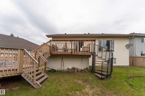 Expansive backyard featuring a multi-level wood deck, a spiral staircase, and a manicured lawn - 183 Dechene Road, Edmonton, AB 