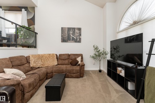 Vaulted ceiling living area featuring light-toned carpet flooring and white painted walls - 183 Dechene Road, Edmonton, AB 
