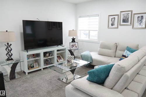 Bright interior space featuring a window with blinds, light-toned walls, and a gray carpeted floor - 17703 74 Street, Edmonton, AB 