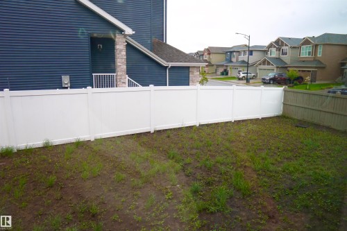 Expansive backyard with a white privacy fence and a wooden fence section - 17703 74 Street, Edmonton, AB 