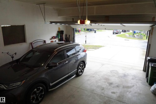 Spacious garage featuring a concrete floor, an overhead door opener, and a single window - 17703 74 Street, Edmonton, AB 