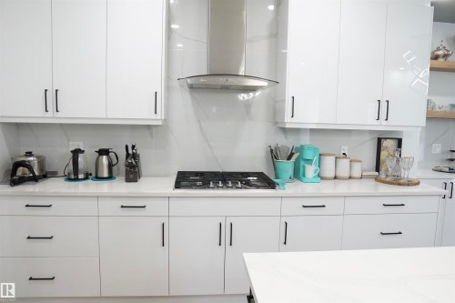 Contemporary kitchen featuring white high-gloss cabinetry with matte black hardware - 17703 74 Street, Edmonton, AB 