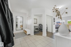 Entryway featuring neutral tile flooring, white walls, recessed lighting, and a full-length mirror - 