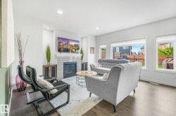 Spacious living area featuring dark wood-finish flooring and multiple windows - 