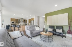 Open-concept living space featuring wood-finish flooring and recessed lighting - 