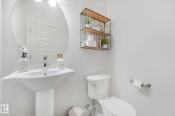 Pedestal sink with chrome faucet and circular mirror - 