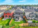 Expansive backyard featuring a manicured lawn, a wooden privacy fence, a multi-level wooden deck, and a hot tub - 556 Merlin Landing Landing, Edmonton, AB 