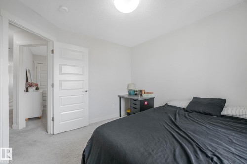 Bedroom with light gray carpeting and a white door featuring five recessed panels - 556 Merlin Landing Landing, Edmonton, AB 