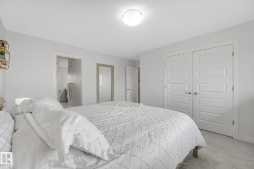 Bedroom featuring white walls, light gray carpet flooring, and a flush mount ceiling light - 556 Merlin Landing Landing, Edmonton, AB 