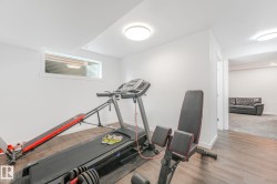 Versatile lower-level room featuring wood-finish flooring, white walls, and a transom window - 