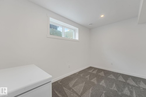 Substantial room featuring a window, recessed lighting, and patterned grey carpeting - 556 Merlin Landing Landing, Edmonton, AB 